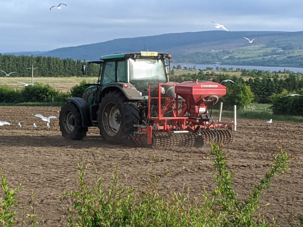 A tractor farming a field cultivating